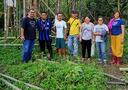 7 people standing in front of a lush trees and forest in the Philippines. The people are smiling and posing for the picture.