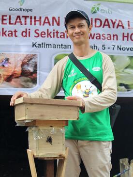 Man in green shirt and baseball cap stands at a podium